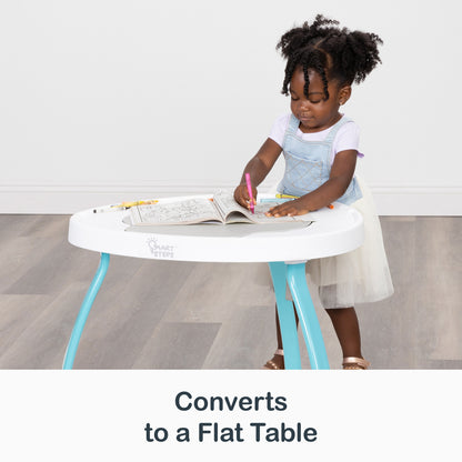 A child is coloring on top of the Smart Steps Bounce N’ Play 3-in-1 Activity Center converted as a flat table